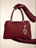 Gia Sling burgundy front view with structured PU leather body, silver-tone hardware and decorative pearl leaf charm | variant:Red