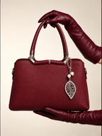 Gia Sling burgundy front view with structured PU leather body, silver-tone hardware and decorative pearl leaf charm