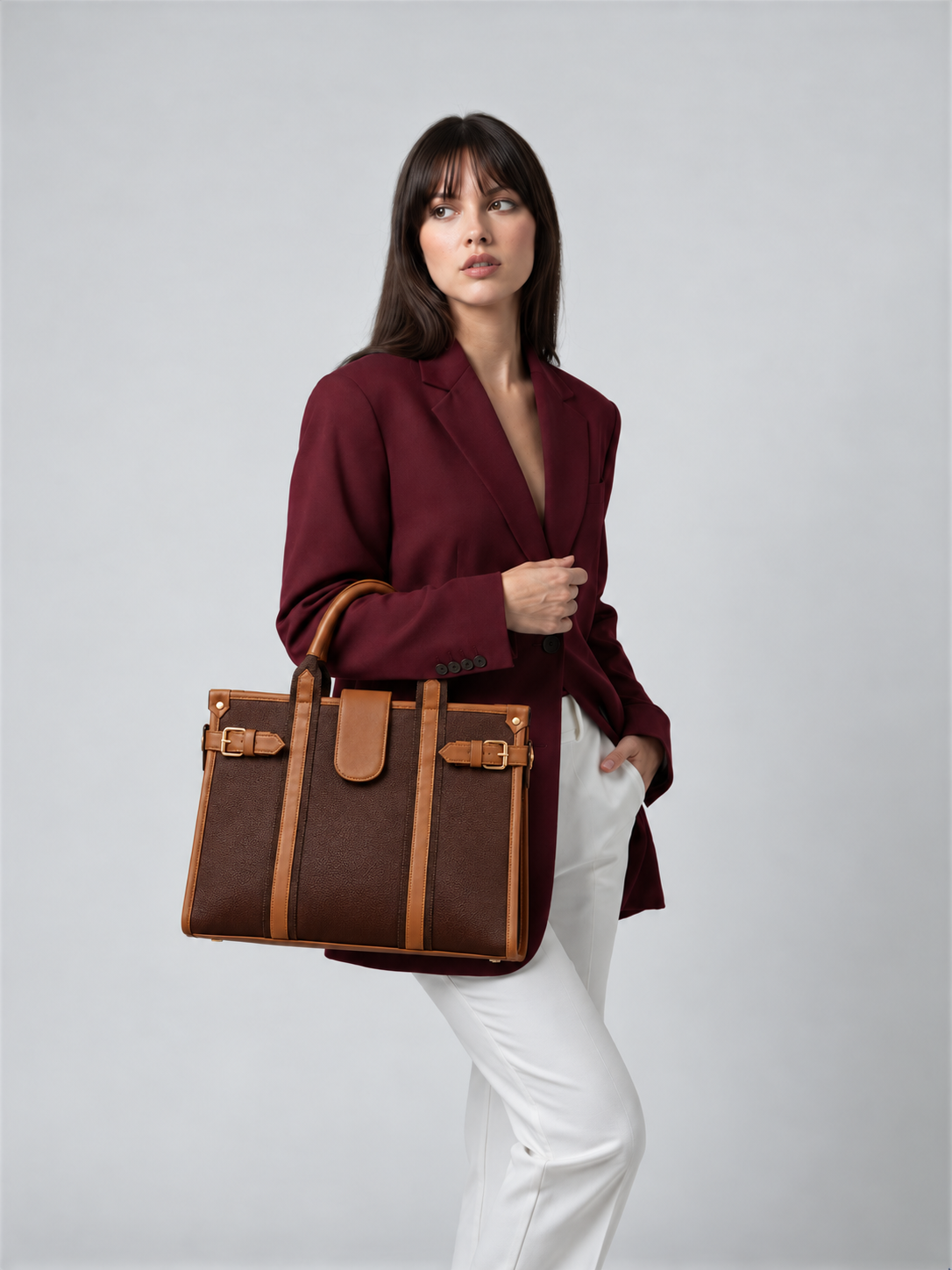 Modern Work Tote lifestyle image in red wine with tan handles, carried by a woman wearing a burgundy blazer