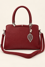 Gia Sling front view in burgundy with detachable shoulder strap, textured PU leather, silver-tone leaf charm and pearl accents