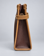 Modern Work Tote side profile in red wine with tan leather trim, structured triangular side panel, adjustable side strap and gold-tone hardware