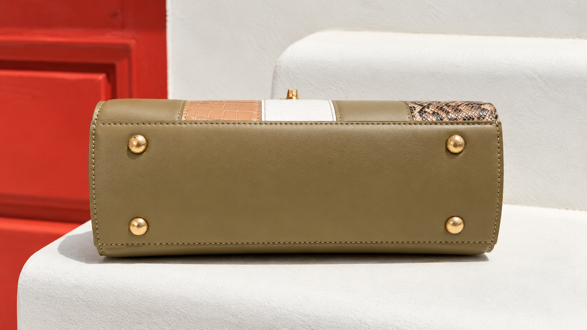 Bela Sling bottom view in olive green showing structured base, neat stitching and four gold-tone protective metal feet